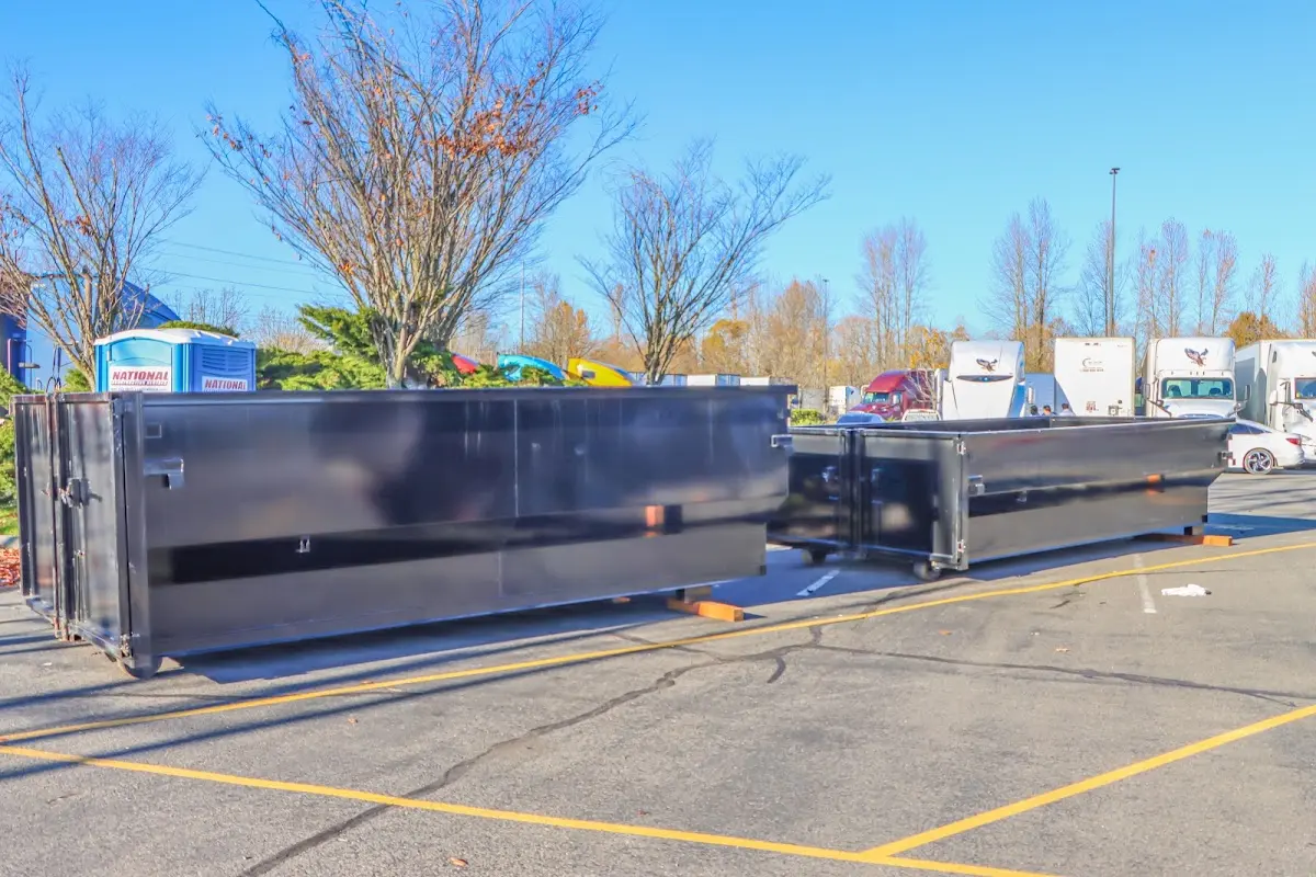 Professional dumpster rental service with roll-off container on residential driveway in Central City